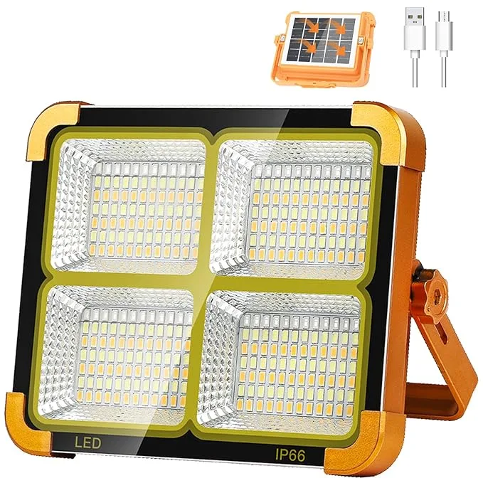 Orange and black solar LED work light with four LED panels, fold-out stand and USB charging cable.